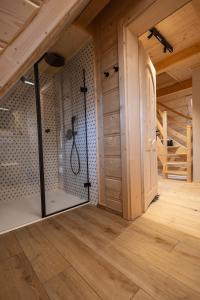a bathroom with a shower in a wooden house at Villa Royal Zakopane in Kościelisko
