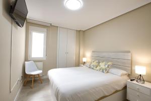 クエンカにあるAP Home Carreteríaの大きなベッドとテレビのある寝室