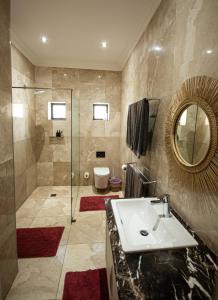 a bathroom with a sink and a shower and a toilet at Walter’s Place in Jongensfontein +36 photos