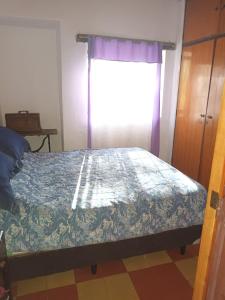 1 dormitorio con 1 cama y ventana en Posta Los Reartes en Los Reartes