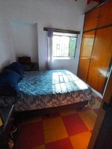 1 dormitorio con 1 cama con tocador y ventana en Posta Los Reartes en Los Reartes