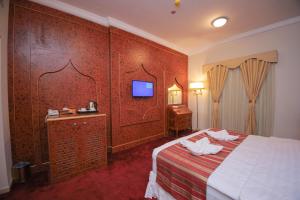 um quarto de hotel com uma cama e uma televisão em Ruba Al Hijaz Hotel em Meca