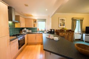 a large kitchen with a black counter top at The Keepers in Aberfeldy