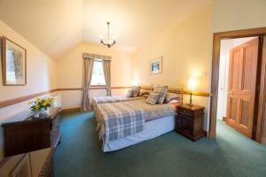 a bedroom with a bed and a table and a window at The Keepers in Aberfeldy