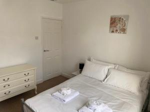 Un dormitorio con una cama blanca con toallas. en Isandula House en Nottingham