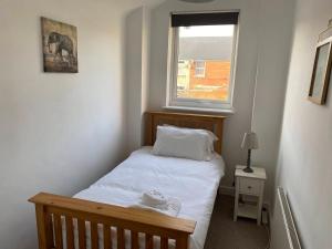 a small bedroom with a bed and a window at Isandula House in Nottingham