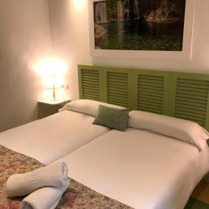 two beds in a room with a painting on the wall at Hostal León Dormido in Polop