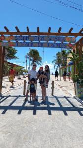 a family standing under a sign at the beach at Torre do Sol in Praia do Frances