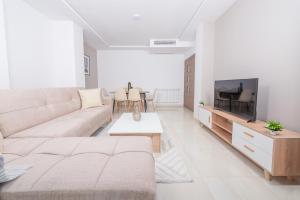 a white living room with a couch and a tv at Appartement Luxueux à Kouba in Kouba