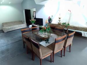 a dining room with a glass table and chairs at Pousada Ponta Grossa in Ponta Grossa