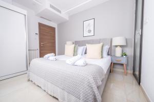 a white bedroom with a large bed with white pillows at Appartement Luxueux à Kouba in Kouba