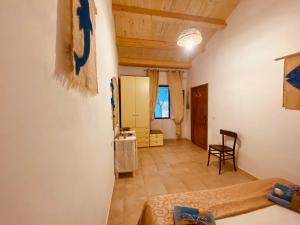 a room with a bed and a table and a chair at Guest House Calalunga Scogliera in Carloforte