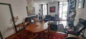 sala de estar con mesa de madera y sillas en Le BETHENCOURT, en Dieppe