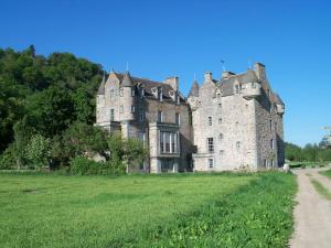 an old castle in a field with a dirt road at Castle Kennels in Aberfeldy