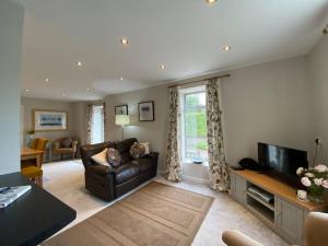 a living room with a couch and a television at Castle Kennels in Aberfeldy