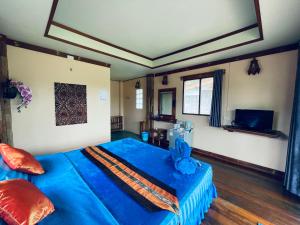 a bedroom with a blue bed with a blue blanket at Markhouse Bungalow Ko Kut in Ko Kood