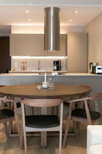 a kitchen with a wooden table and some chairs at Arctic Circle Holiday homes II in Rovaniemi