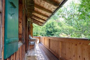 een veranda van een hut met een houten hek bij Chalet Le Monteiller in Les Moulins