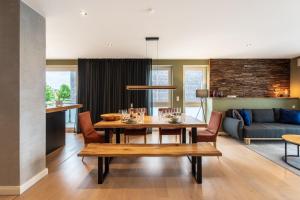 een eetkamer en een woonkamer met een houten tafel bij LUXX APARTMENTS I Luxx Central I Design I Komfort in Bad Zwischenahn
