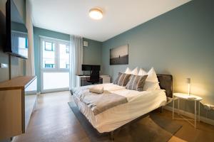 ein Schlafzimmer mit einem großen Bett mit blauen Wänden in der Unterkunft LUXX APARTMENTS I Luxx Central I Design I Komfort in Bad Zwischenahn
