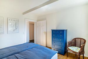 a bedroom with a blue bed and a chair at Merkurblick in Baden-Baden