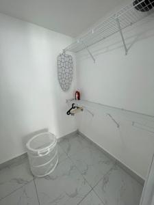 een witte kamer met een emmer in de hoek bij Agreable Duplex tout confort. in Santo Domingo