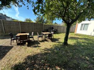a table and chairs under a tree in a yard at North London A spacious 7 bedroom house accommodating up to 18 people complete with own gym and table tennis in London