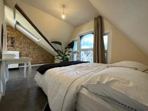 a bedroom with a white bed and a window at North London A spacious 7 bedroom house accommodating up to 18 people complete with own gym and table tennis in London