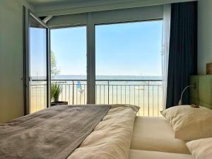 ein Schlafzimmer mit einem Bett und einem großen Fenster in der Unterkunft Seespitz Gästehaus in Herrsching am Ammersee