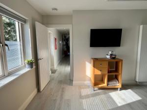 a living room with a television on a wall at Harbour view retreat Cró na mbó in Midleton