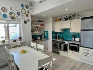 a kitchen with a white table and chairs in a room at Harbour view retreat Cró na mbó in Midleton