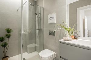 a bathroom with a shower and a toilet and a sink at Apartamentos Pamplona by Clabao in Pamplona