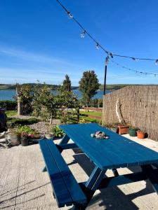 a blue picnic table with a cat sleeping on it at Harbour view retreat Cró na mbó in Midleton