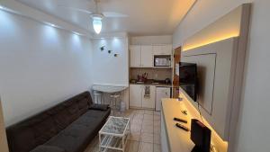 sala de estar con sofá y cocina en Apartamento de 1 quarto de frente a praia dos Ingleses, en Florianópolis