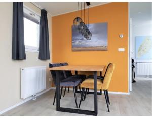 a dining room with a wooden table and chairs at Knus chalet Heidebloem in Putten