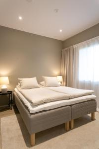 a large bed in a bedroom with a window at Arctic Circle Holiday homes II in Rovaniemi