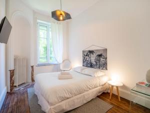 a white bedroom with a bed and a window at Le chic de Patton avec jardin privatif ! in Nancy