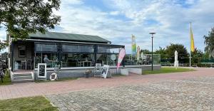 a building with a dog sitting outside of it at KUHNLE-TOURS GmbH Malchin in Malchin