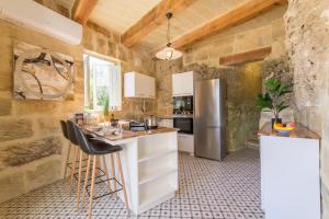 una cucina con bancone e frigorifero di Pleasant stone house & jacuzzi St Martin - Happy Rentals a Mġarr