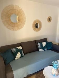 a living room with a blue couch and two mirrors at Fos Plage - Studio in Fos-sur-Mer