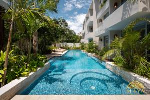 a swimming pool in front of a building at NHOA 112C Lux 1BR Condo Plunge Pool in Aldea Zama in Tulum +25 photos