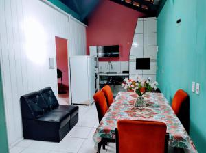 une salle à manger avec une table et des chaises ainsi qu'une cuisine dans l'établissement Apto com piscina 3 quartos 500m do mar praia Ubatuba, à São Francisco do Sul