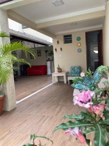 a living room with plants and a wooden floor at Casa Brisas Arembepe - arejada e aconchegante - litoral norte da Bahia com crianca - WiFi in Arembepe