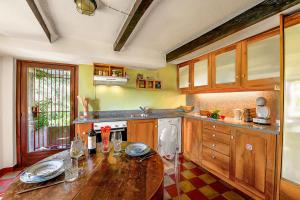 a kitchen with a wooden table and a sink at Casa Dell'Antonio - Happy Rentals in Aranno