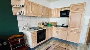 eine Küche mit Holzschränken und einem schwarzen Gerät in der Unterkunft Ferienwohnung Ida Pfeiffer in Eibenstock