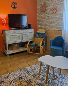 a living room with a tv and two chairs at GITE LES GOUTTES in Courzieu