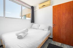 een kleine slaapkamer met een bed en een raam bij relaxing duplex in ashdod by torohome in Ashdod
