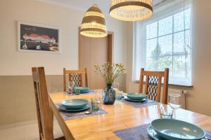 een eetkamer met een houten tafel en stoelen bij Sopocki Apartament przy Plaży in Sopot