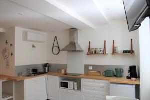 a kitchen with white cabinets and a counter top at O'BERCAIL in Tournon-sur-Rhône