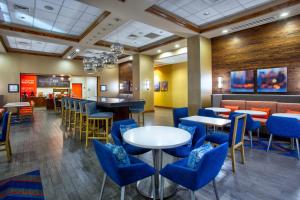 a restaurant with blue chairs and tables and a bar at Hampton Inn & Suites Columbia/Southeast-Fort Jackson in Columbia